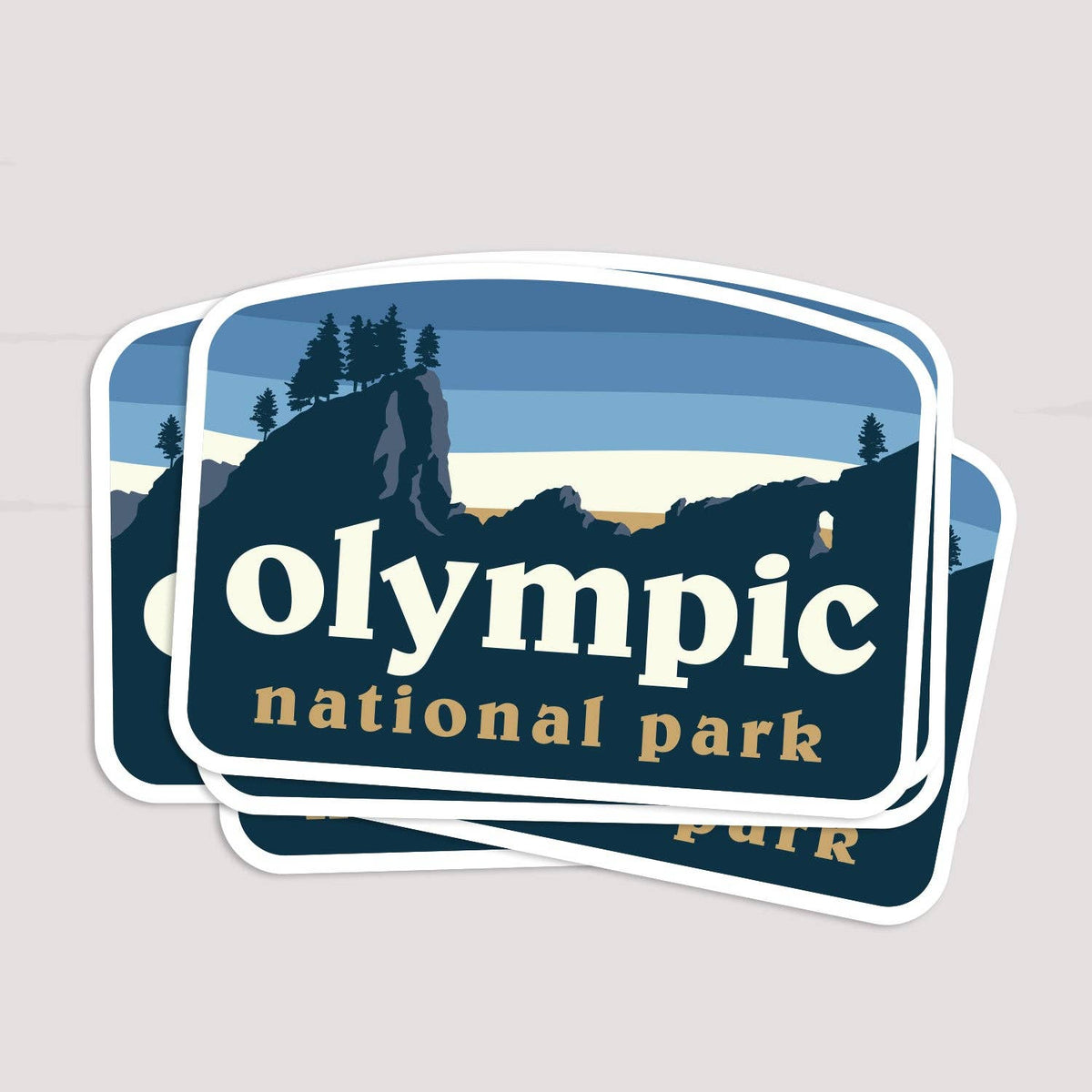 Three copies of the Olympic National Park sticker fan out in a loose stack on a pale grey surface.