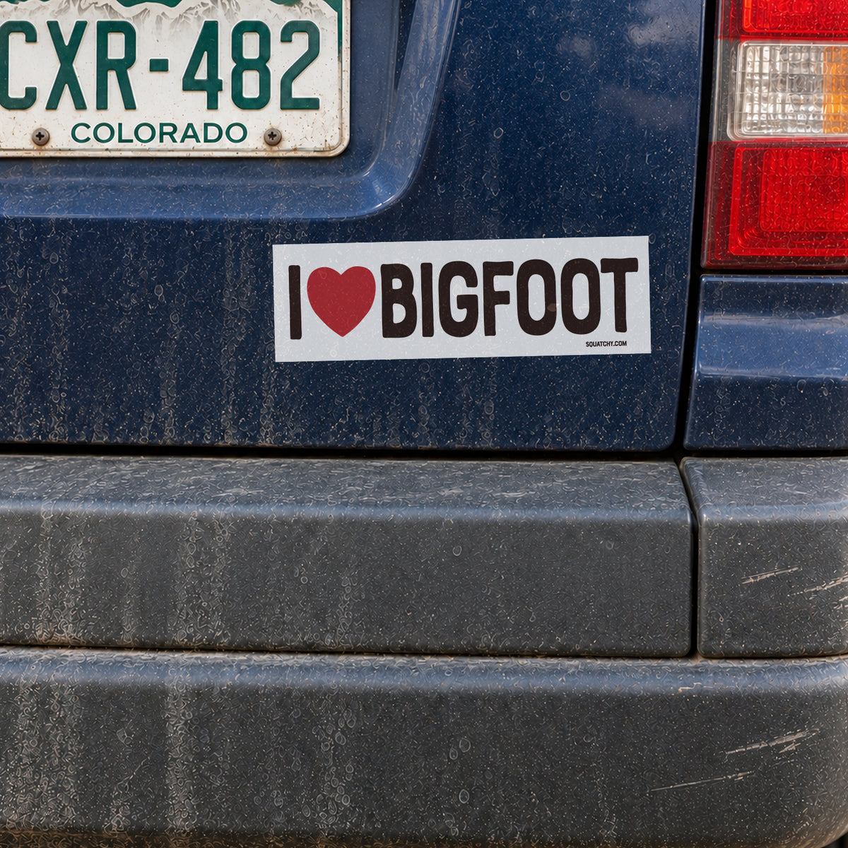 The I Heart Bigfoot sticker sits centered on a dusty blue bumper under a Colorado license plate.