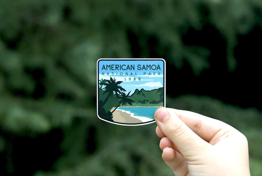 Farther back against the same dark foliage, the American Samoa National Park sticker sits small in a hand.