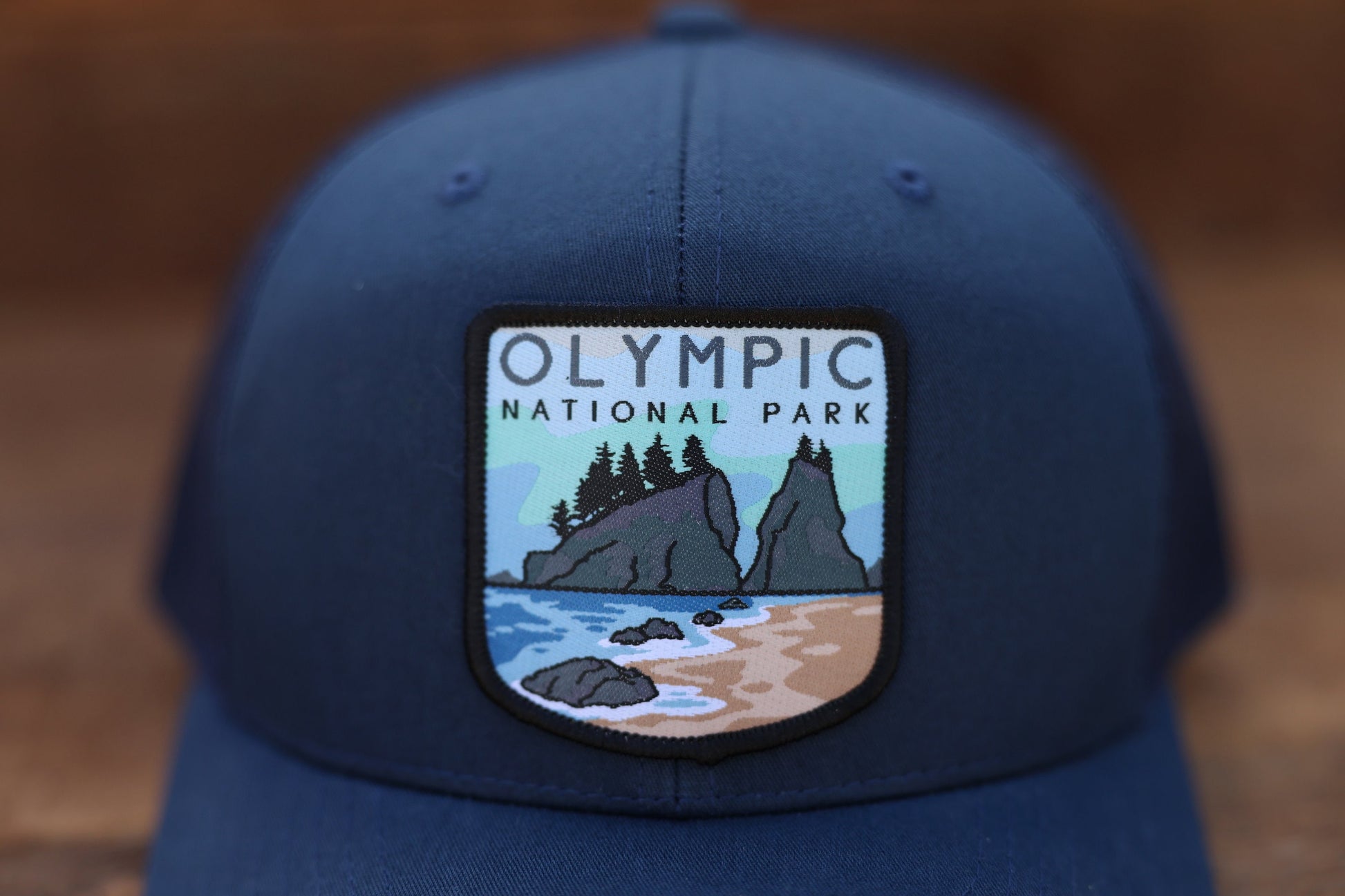 The stitched border of the Olympic National Park patch stands out on deep blue twill in close focus.