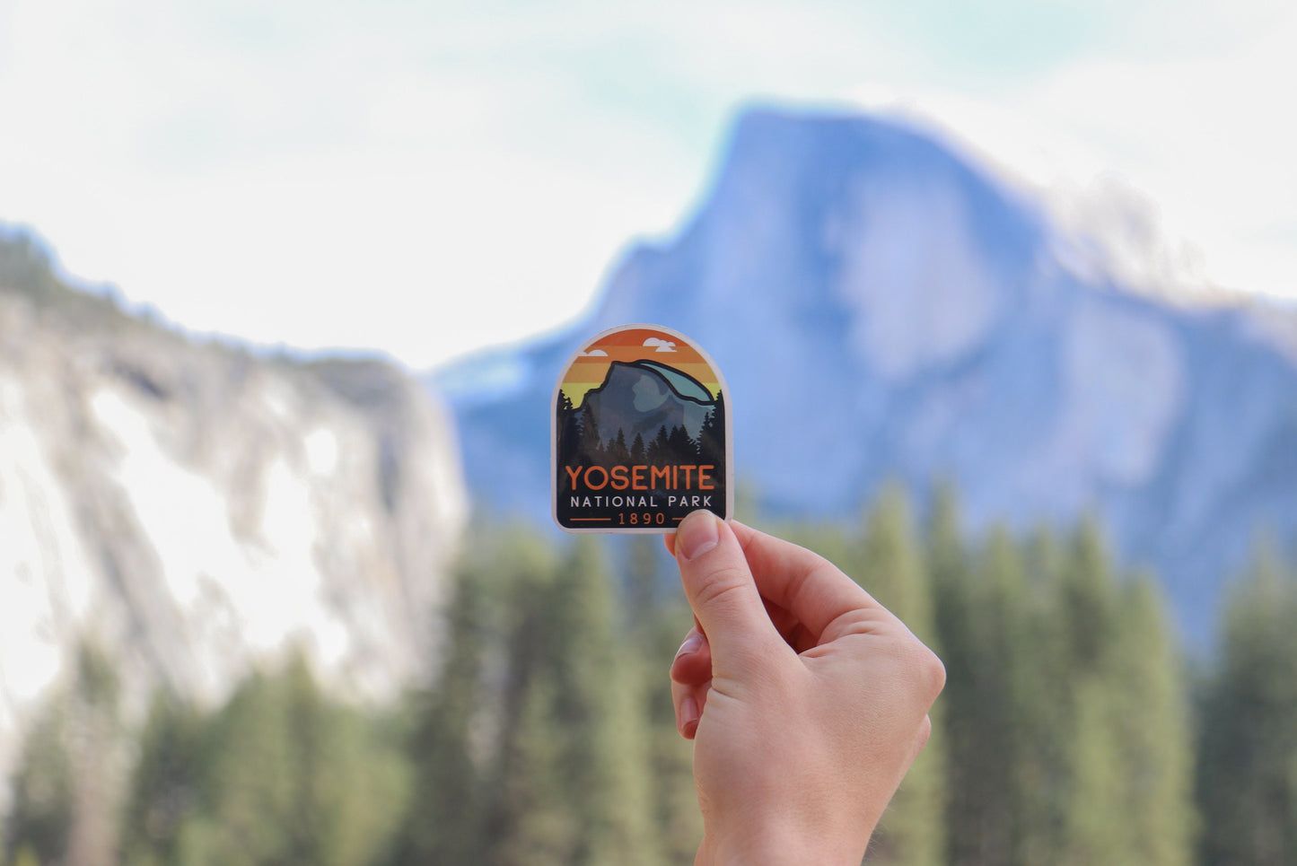 Raised toward the real Half Dome, the Yosemite National Park sticker lines up with the granite face.