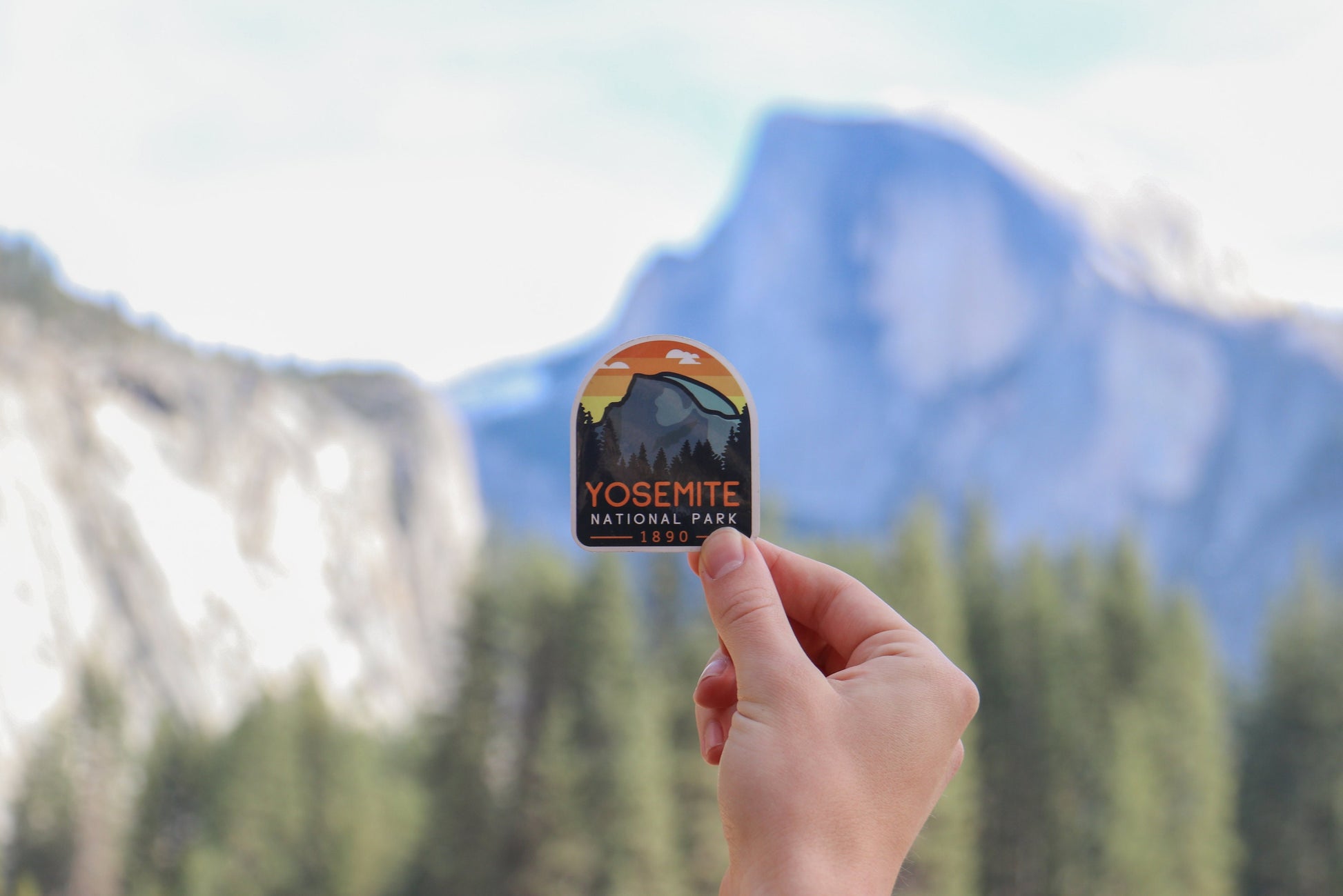 Raised toward the real Half Dome, the Yosemite National Park sticker lines up with the granite face.