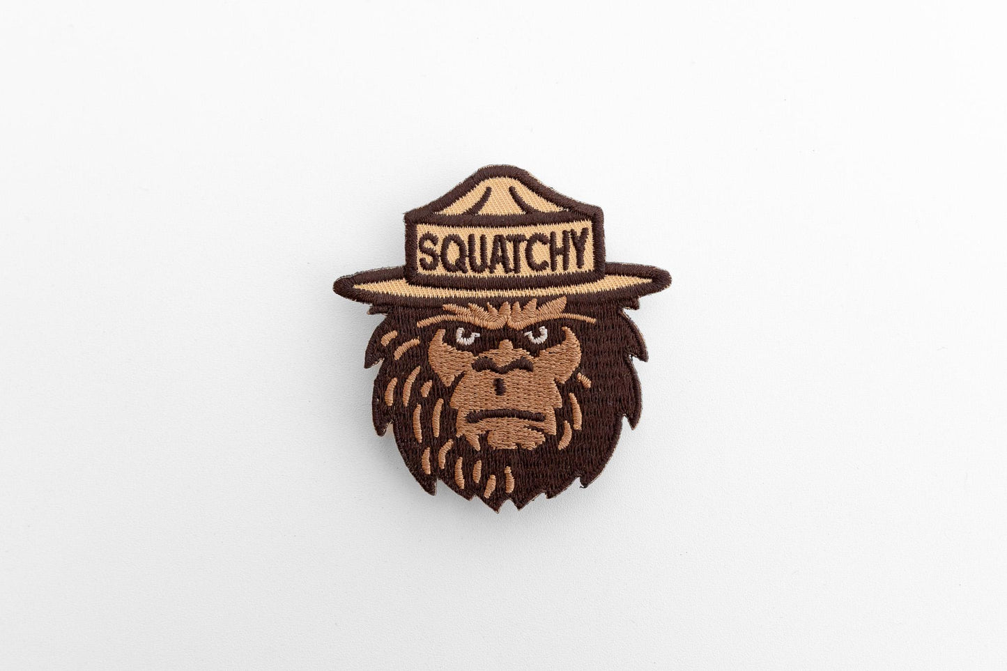 Laid flat and shot from above, the Squatchy patch fills the center of a bright white surface.