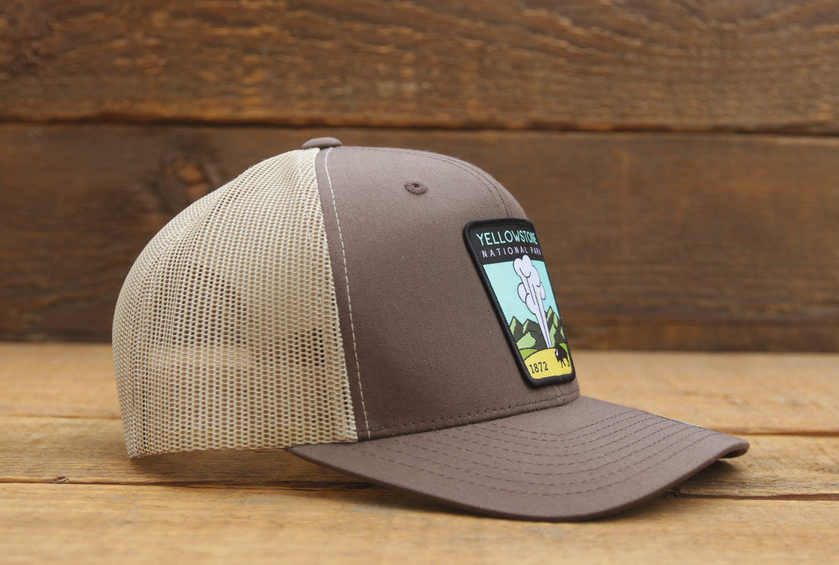 From the right side, the brown Yellowstone trucker hat shows a curved brim and light tan mesh panels.