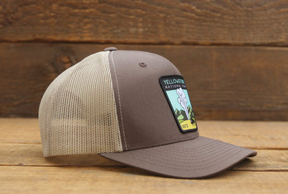 From the right side, the brown Yellowstone trucker hat shows a curved brim and light tan mesh panels.