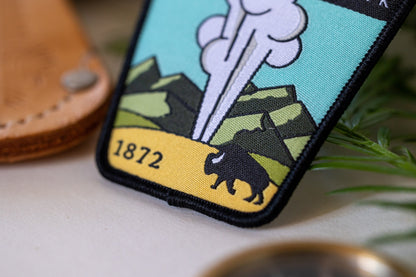 Close crop on the lower corner of the Yellowstone National Park patch, where the bison walks a yellow plain.