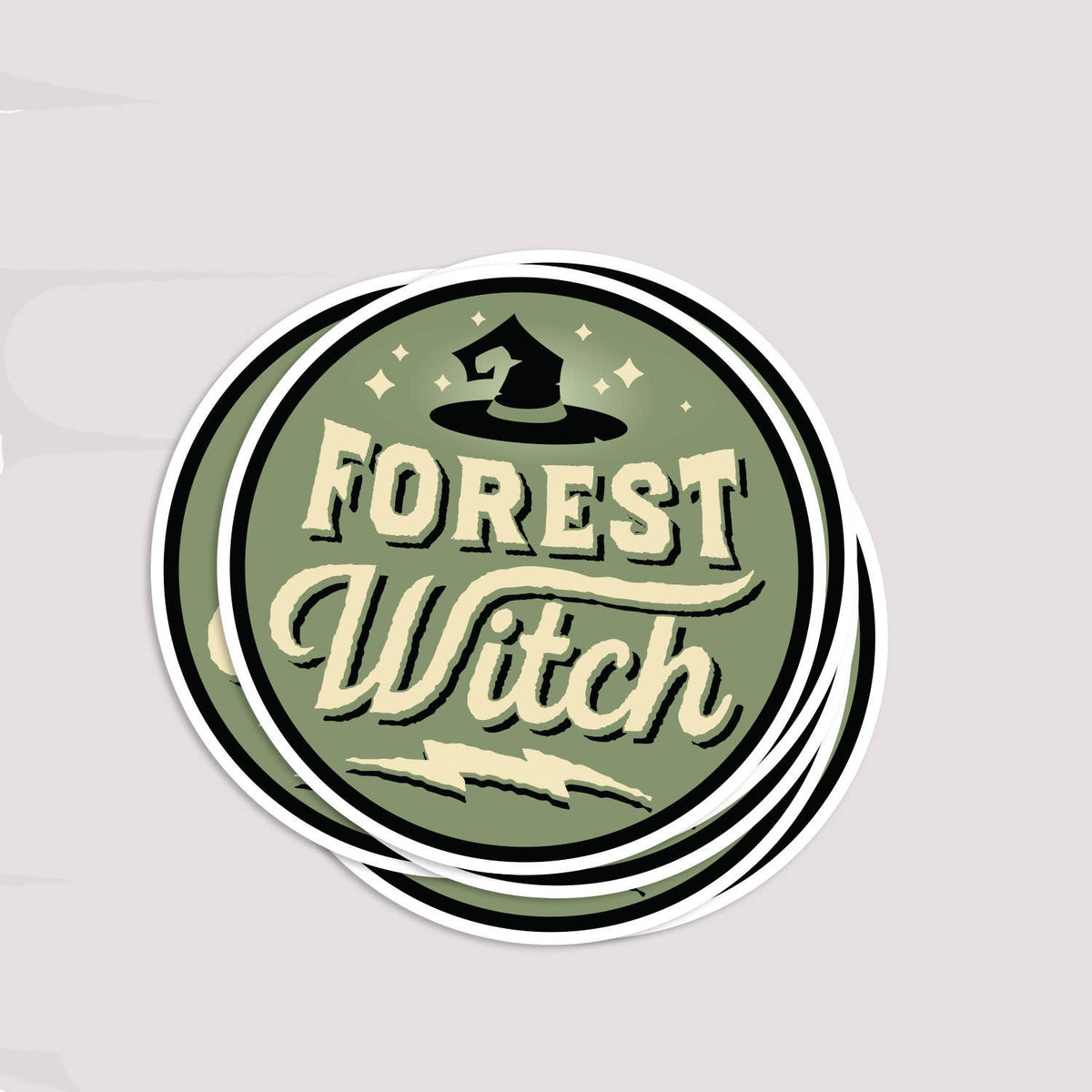 A small stack of Forest Witch stickers fanned slightly on a pale grey surface.