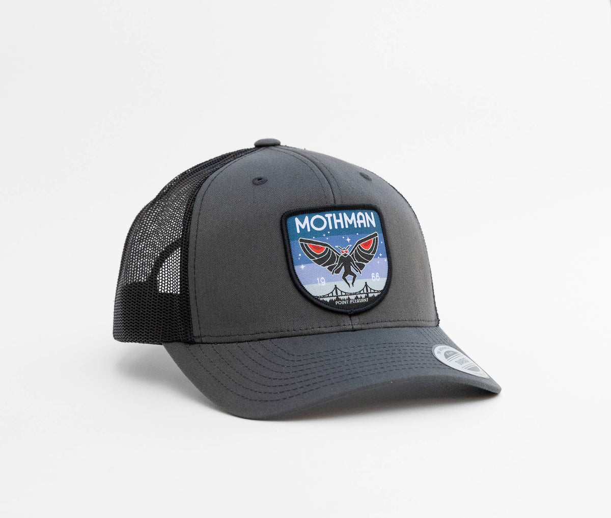 Charcoal front panel and black mesh sides on the Mothman trucker hat, with the winged patch centered above the brim.