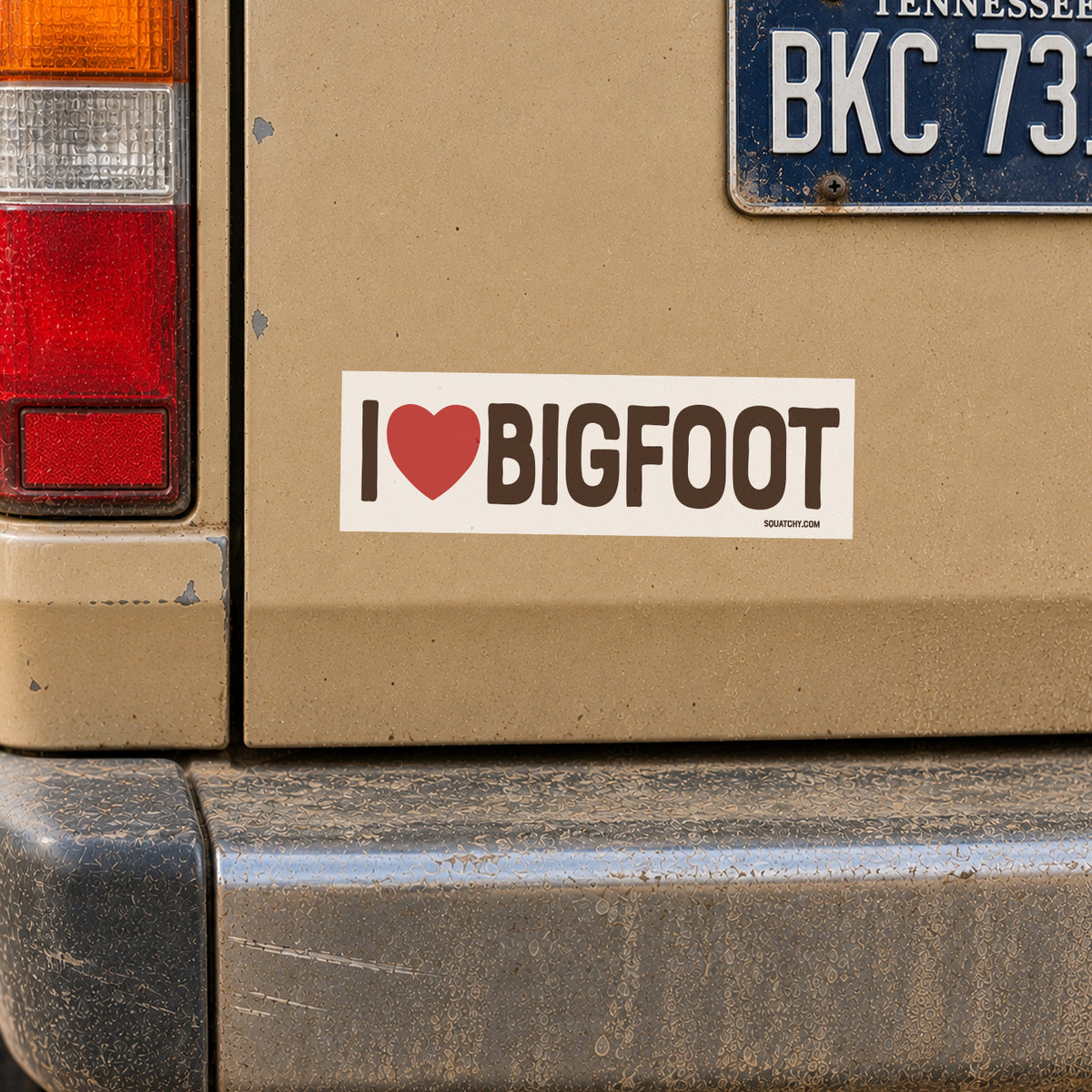The I Heart Bigfoot sticker rides on a tan truck door below a Tennessee plate and a dinged bumper.