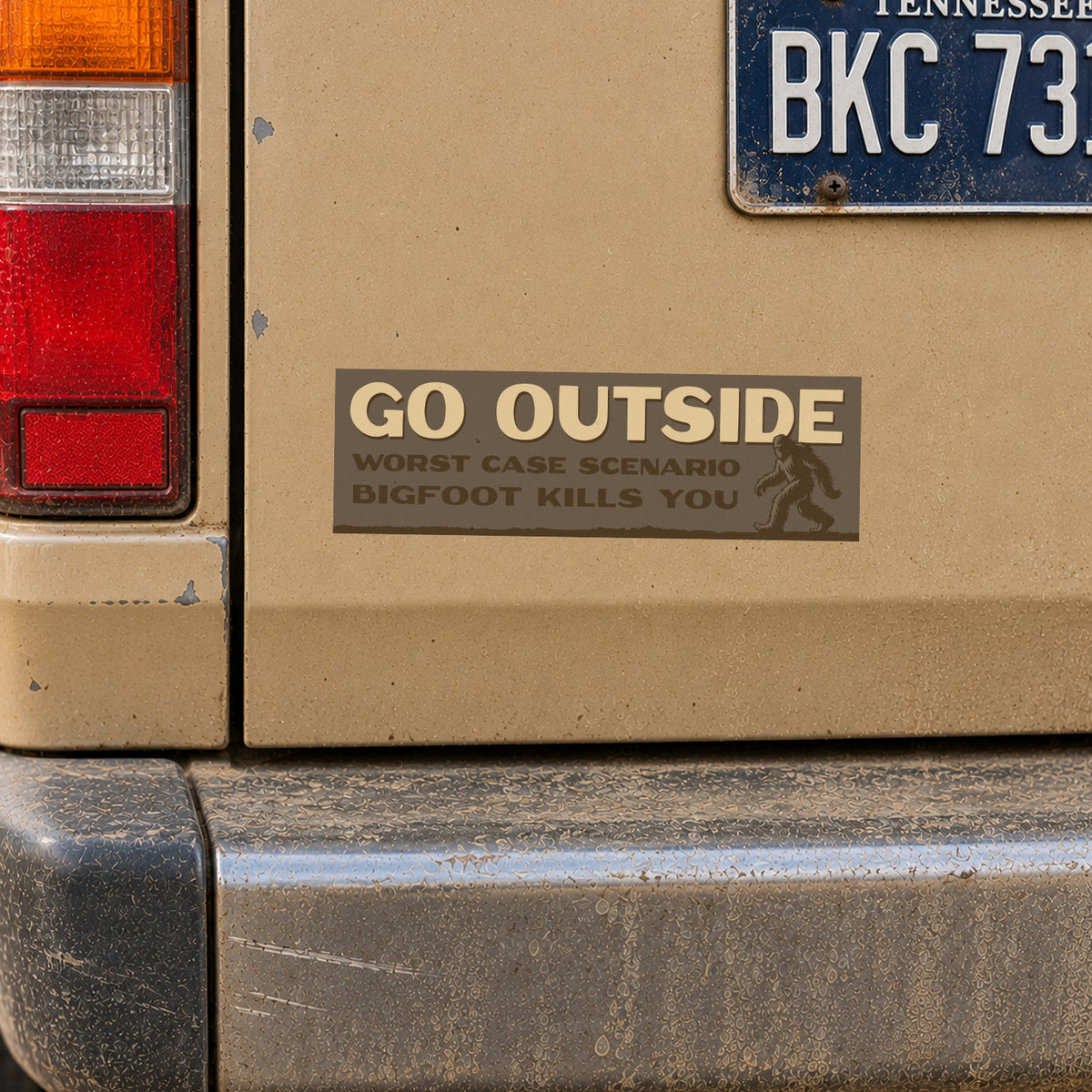 Dust coats the tan bumper where the Go Outside Bigfoot Kills You sticker sits near a Tennessee license plate.
