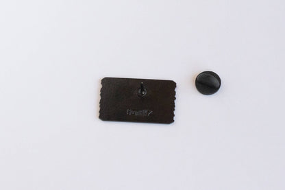 Back side of the Welcome to Colorful Colorado pin with its post, stamped logo and rubber clutch set apart.