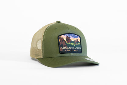 Olive green crown with tan mesh, the Garden of the Gods Colorado trucker hat shows its sunset spires patch.