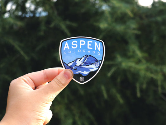 Held a little farther back, the Aspen Colorado sticker shows its snowy peaks and small snowflake below the trees.