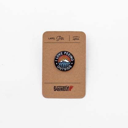 On its kraft Squatchy backing card, the I Love Peeing Outside pin shows a mountain and sunrise design in enamel.