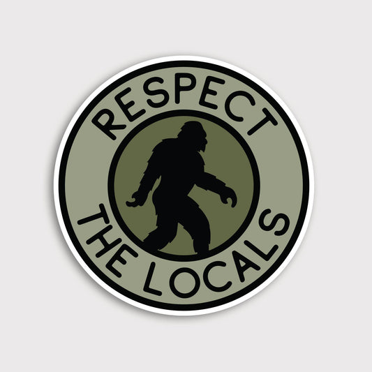 Round olive Bigfoot Respect The Locals sticker on a plain grey background, black silhouette mid stride.