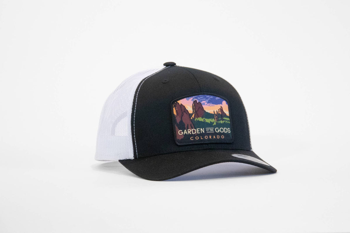 Black and white Garden of the Gods Colorado trucker hat angled to show the red rock patch on the front panel.