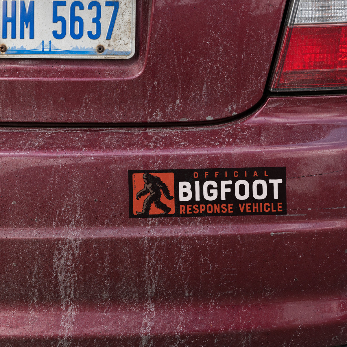 Applied to a maroon bumper, the Official Bigfoot Response Vehicle sticker sits below a chrome tail light.