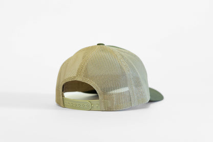 Rear view of the olive trucker hat, khaki mesh panels above a light green snapback strap.