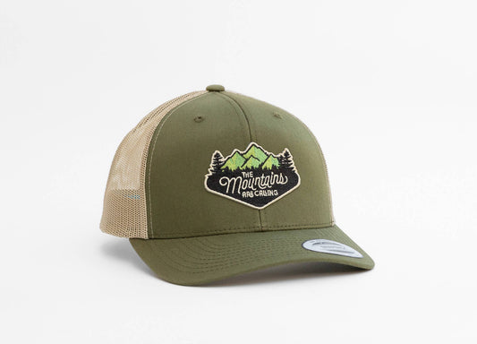 Olive front and khaki mesh on The Mountains Are Calling trucker hat, patch centered above a curved green brim.