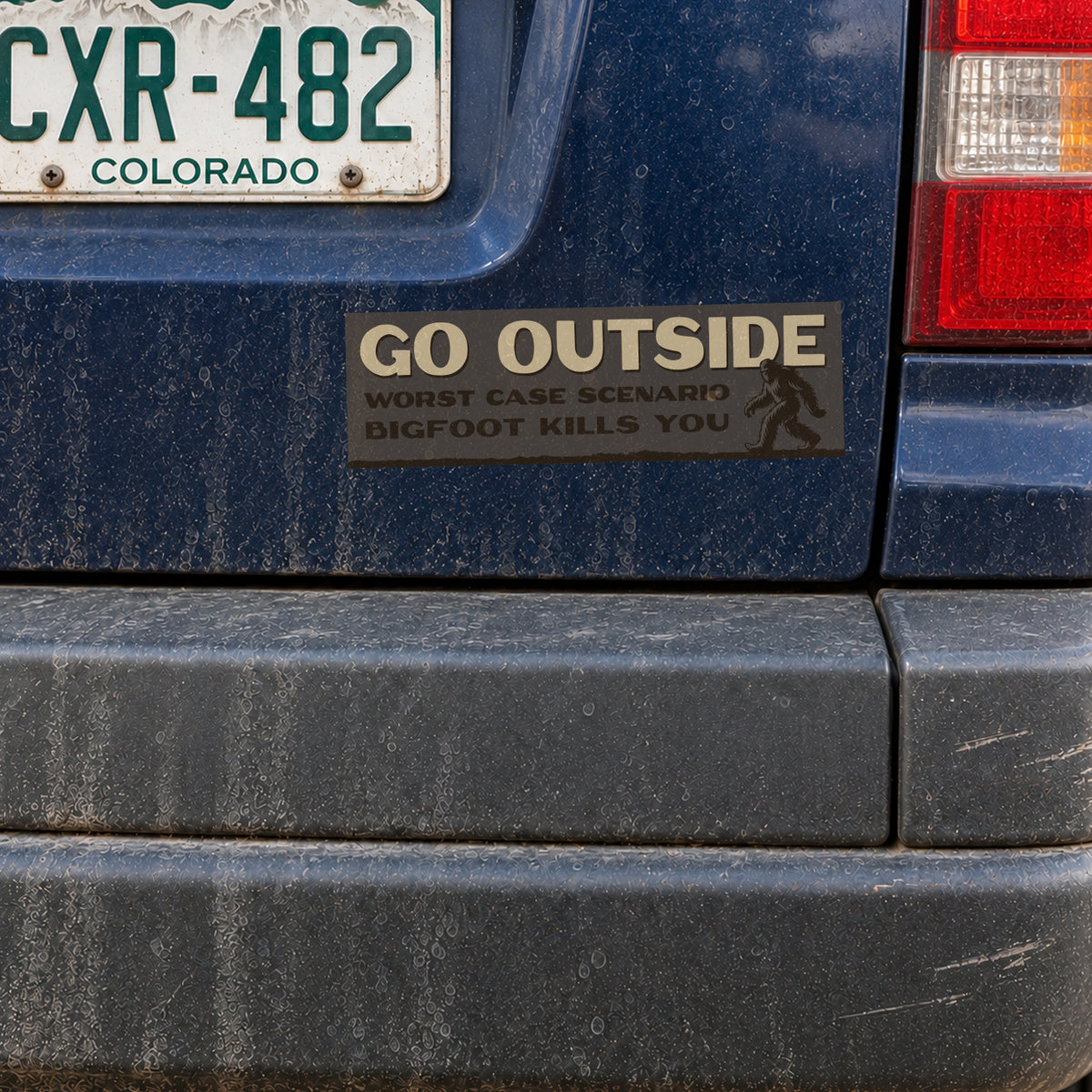 A blue SUV's rear panel holds the Go Outside Bigfoot Kills You sticker just under a Colorado license plate.
