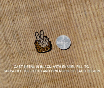 Next to a nickel on pale wood, the Bigfoot Peace Pin is shown for scale with a note about cast metal.