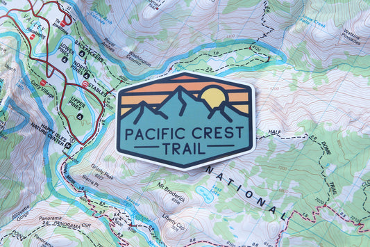 Resting on a topographic trail map, the Pacific Crest Trail sticker covers contour lines and creek names.